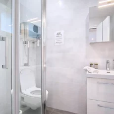 Salle de bain moderne avec douche et lavabo.