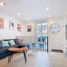 Salon moderne avec canapé et décoration murale.