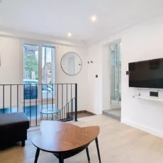 Salon moderne avec télévision murale et canapé.