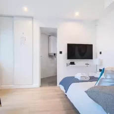 Chambre moderne avec lit double et télévision.