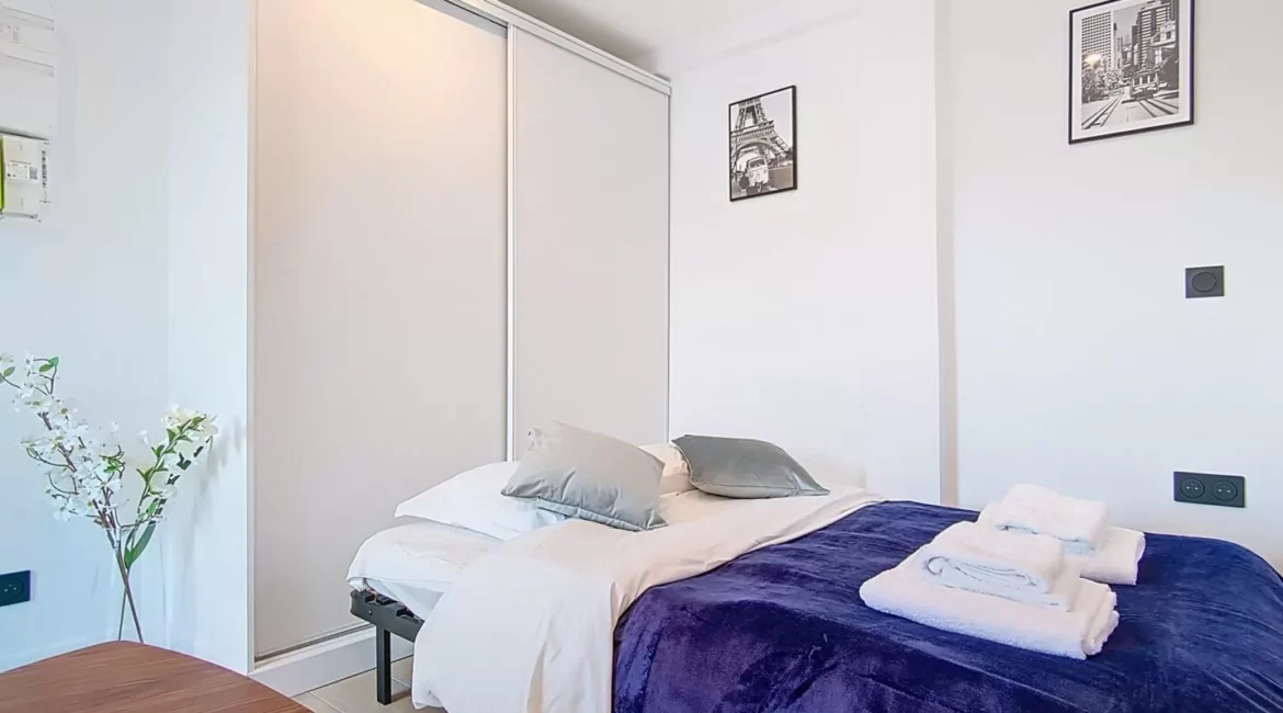 lit location studio voyage argenteuil Chambre moderne avec lit et décoration minimaliste.