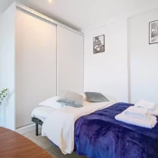 lit location studio voyage argenteuil Chambre moderne avec lit et décoration minimaliste.