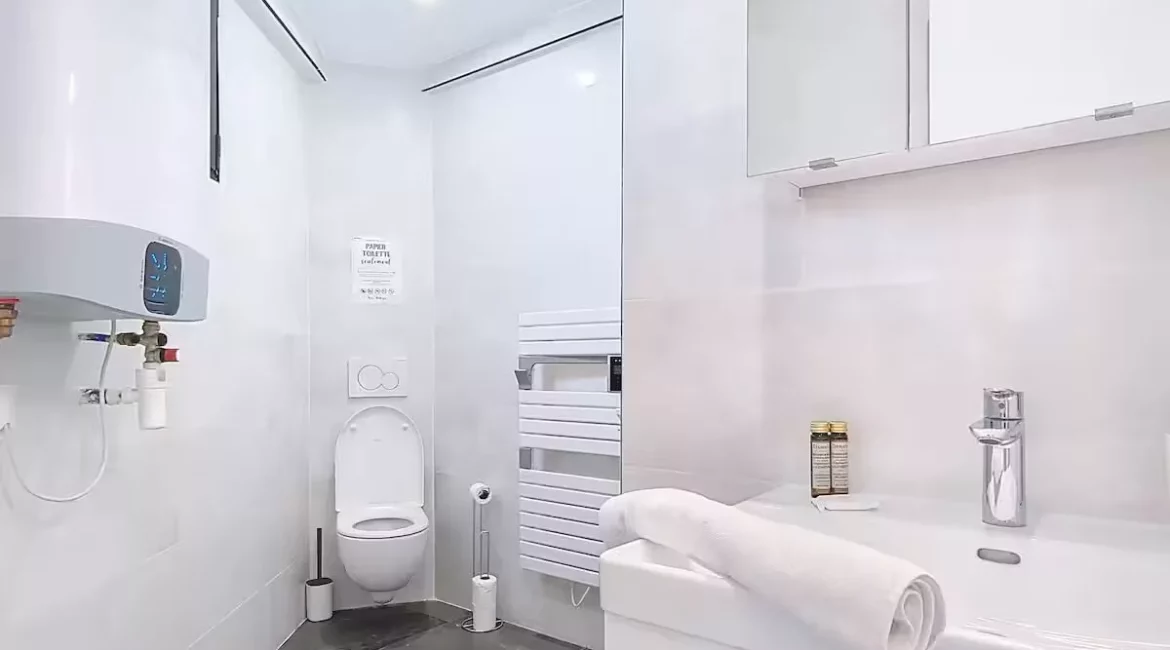 Salle de bain moderne avec sanitaires blancs.