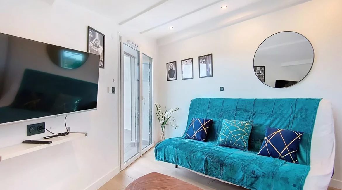 salon appartement vie d'artiste argenteuil Salon moderne avec canapé et télévision murale.