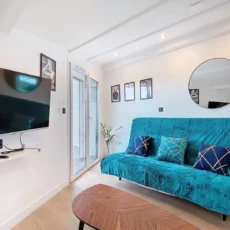 salon appartement vie d'artiste argenteuil Salon moderne avec canapé et télévision murale.