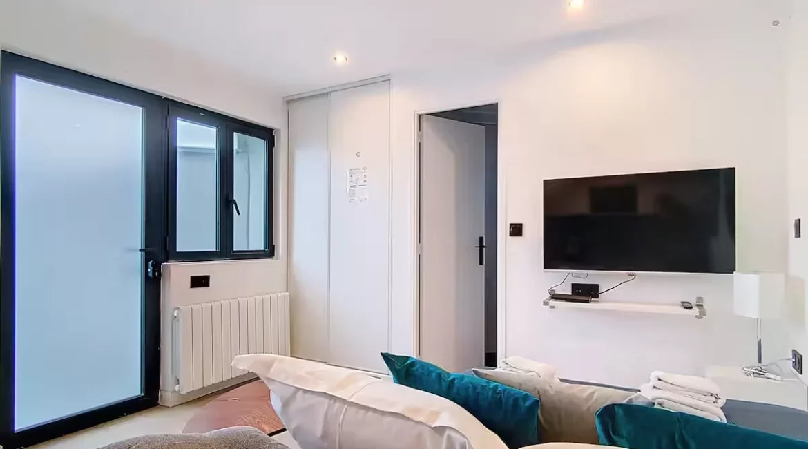 Chambre moderne avec télévision et canapé.