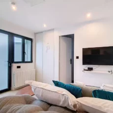 Chambre moderne avec télévision et canapé.