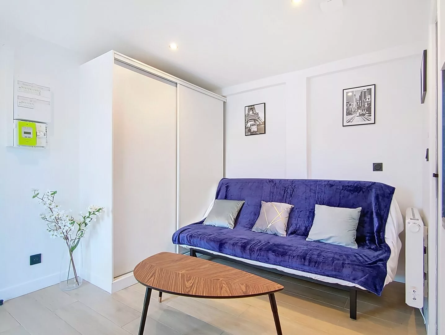 Salon moderne avec canapé bleu et décorations murales.