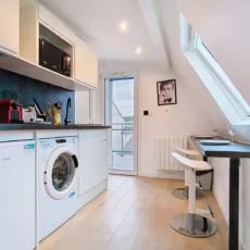 vue cuisine appartement vie d'artiste argenteuil Cuisine moderne avec appareils électroménagers et coin repas.