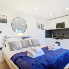 Studio moderne avec lit, cuisine équipée.