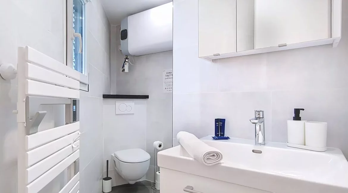 Salle de bain moderne avec douche et lavabo.
