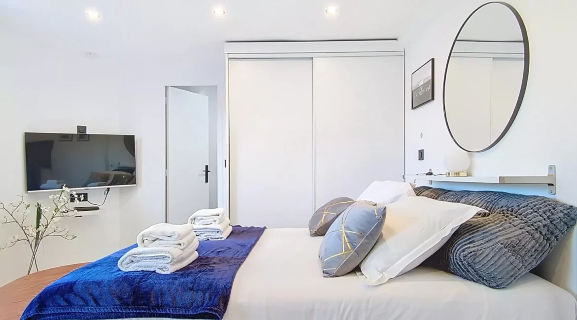 Chambre moderne avec lit et télévision.