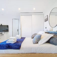 Chambre moderne avec lit et télévision.